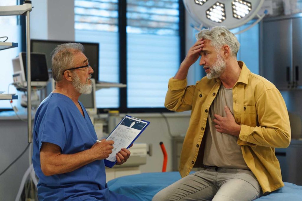 Man with chest pain and headache talking to doctor at Ambetter-accepted urgent care in Gulfton