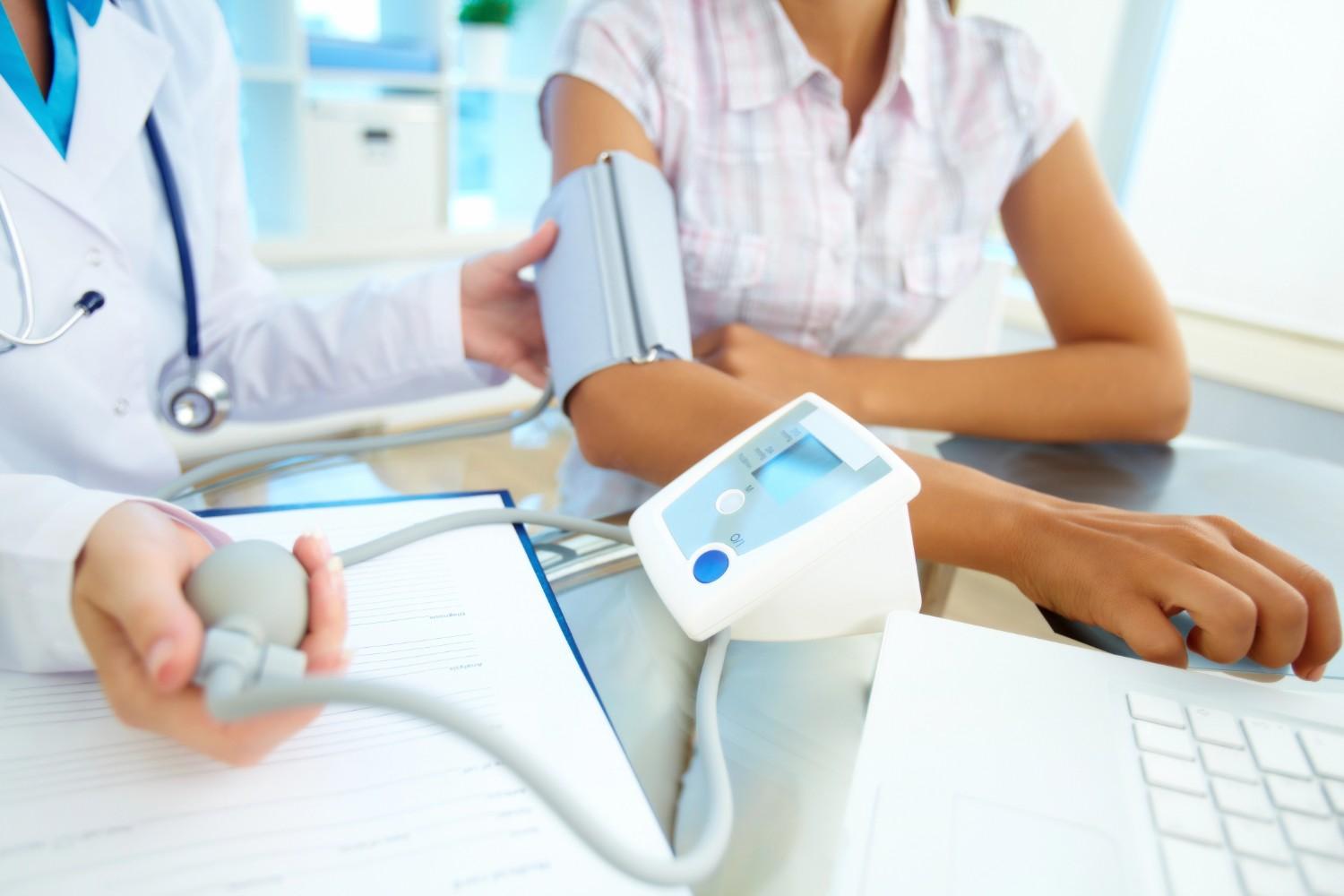 Doctor taking blood pressure at an urgent care that accepts Ambetter in Mahatma Gandhi District