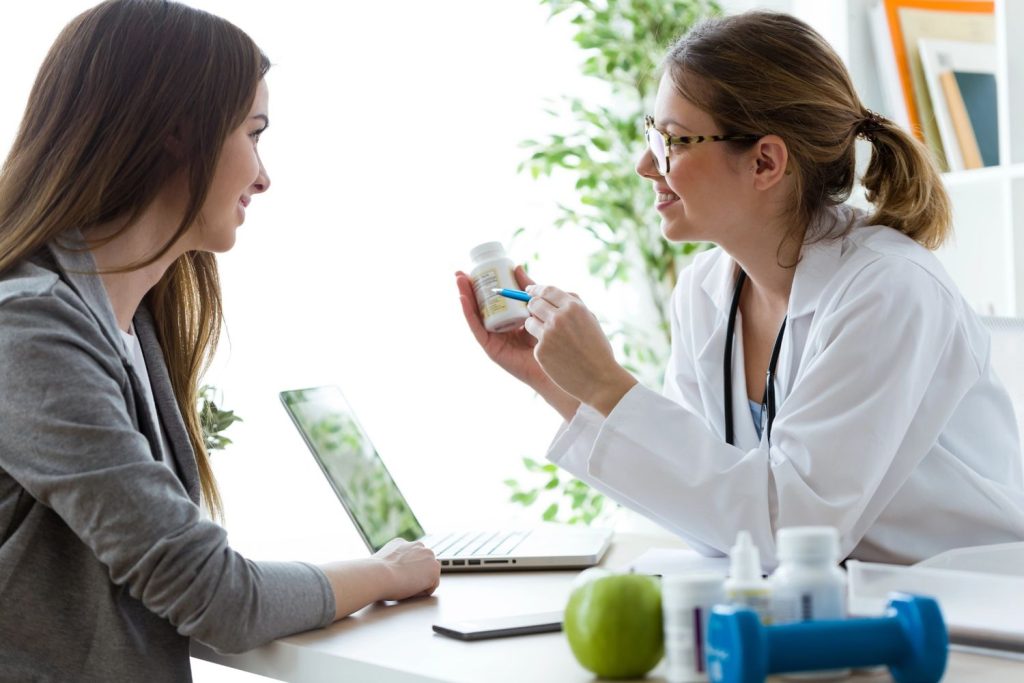 A doctor discussing medication with a patient at a 24-hour walk-in clinic accepting Ambetter insurance.