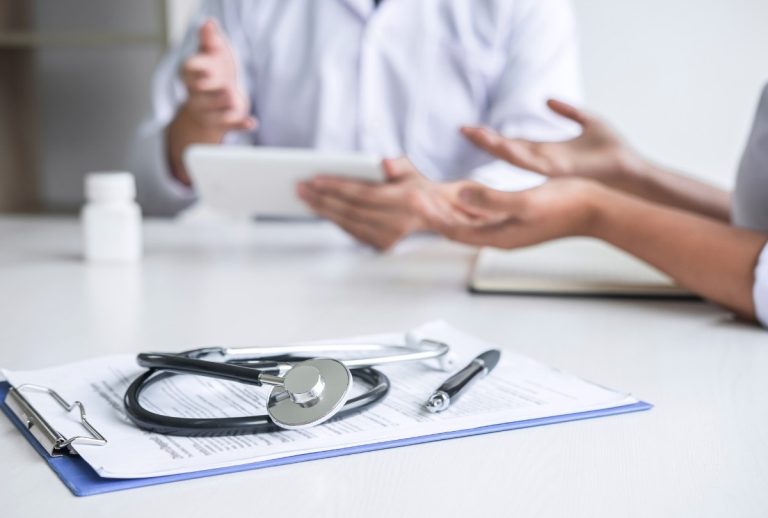 Ambetter accepted doctors Houston collaborate on patient care using tablet and clipboard in modern clinical consultation.