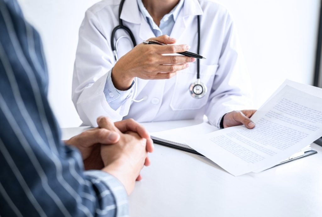 Ambetter accepted doctors Houston review medical records and treatment options with patient in professional consultation.