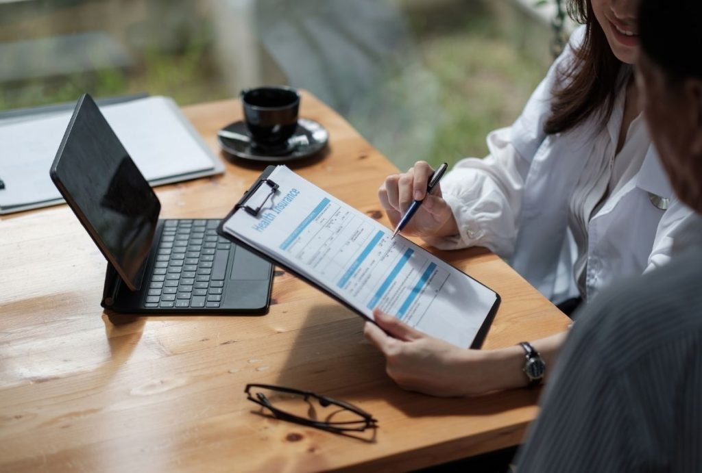 Consultation reviewing Health Insurance policy details — Ambetter Accepted Doctors Houston, benefits, dates, and eligibility explained