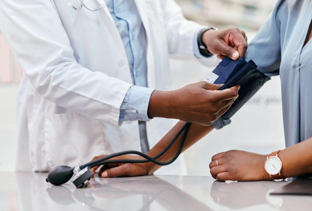 Doctor measures patient’s blood pressure with cuff and stethoscope — Ambetter Accepted Doctors Houston preventive heart health