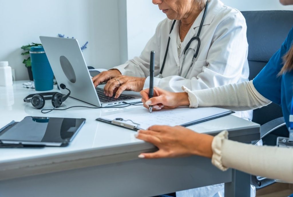 Medical team collaborates in clinic offering Ambetter approved urgent care services with patient records and digital tools.