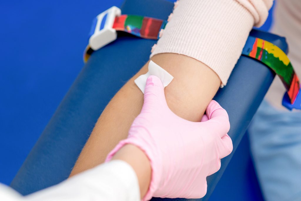 A medical professional prepares a patient for testing at an Urgent Care Clinic Houston with safe blood draw practices.