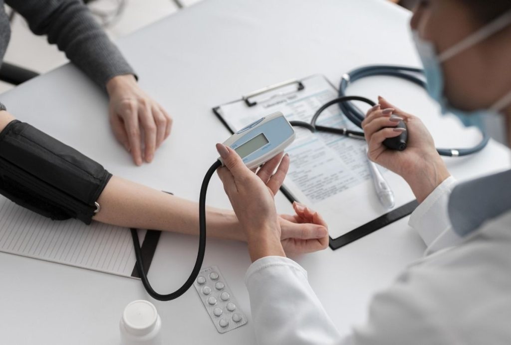 Doctor measuring patient’s blood pressure with a digital monitor during a routine check-up at Walk-In Clinic Houston, emphasizing fast and accessible health screenings.
