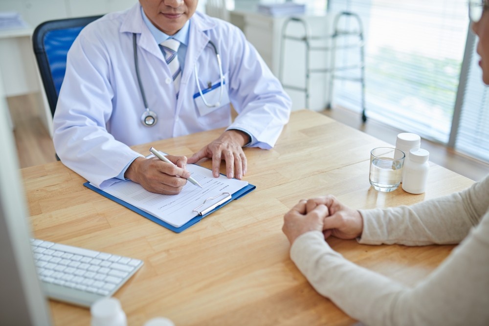 Healthcare provider in white coat documenting patient visit on clipboard during walk-in clinic consultation at Walk-In Clinic Houston.