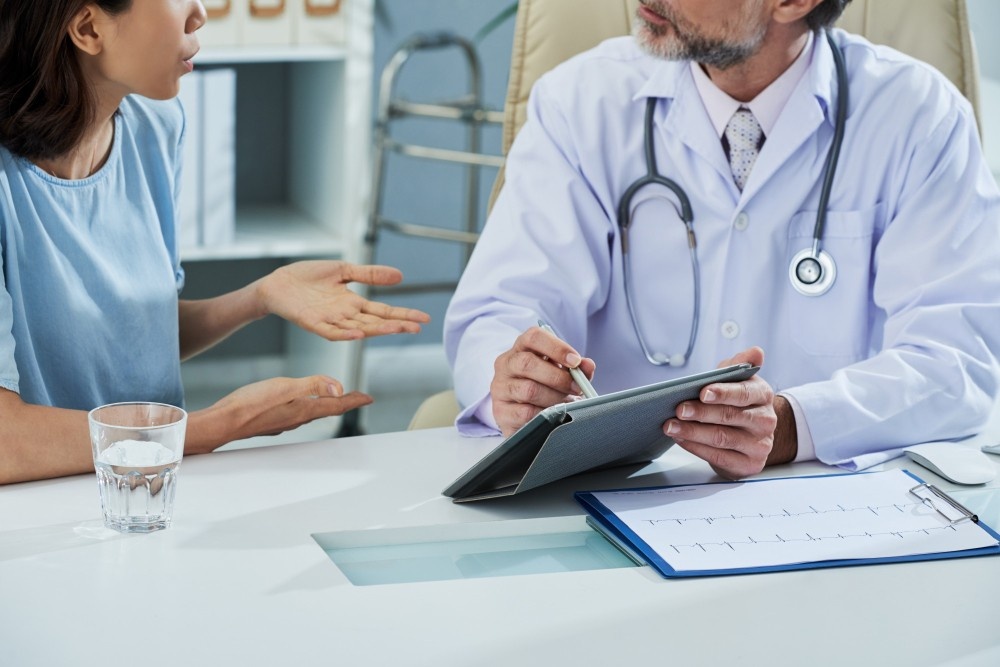 Doctor using digital tablet during patient consultation at walk-in clinic, emphasizing accessible care options at Walk-In Clinic Houston.