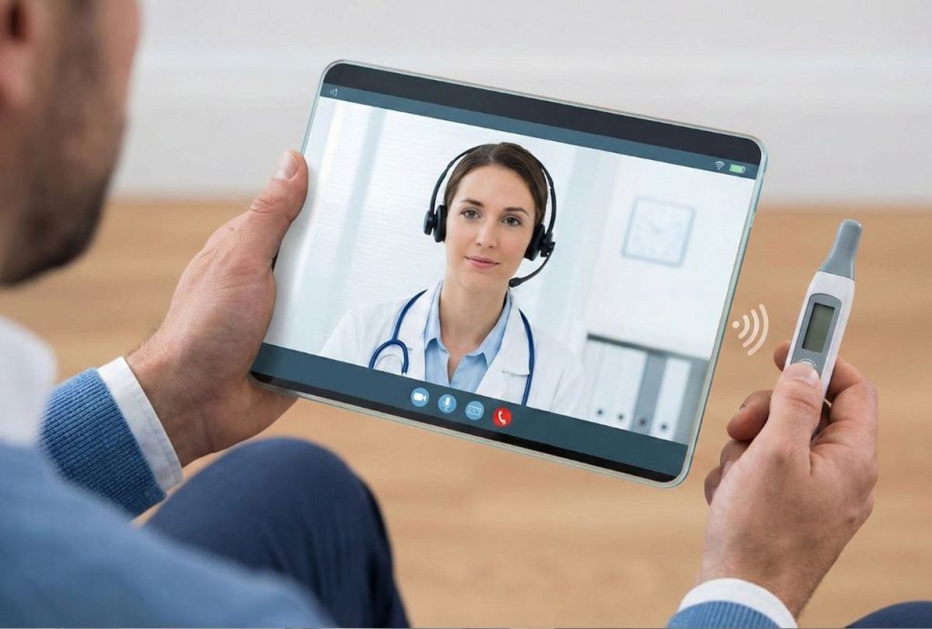 Patient holding a digital thermometer during a virtual consult to discuss a fever and strep throat test urgent care options.