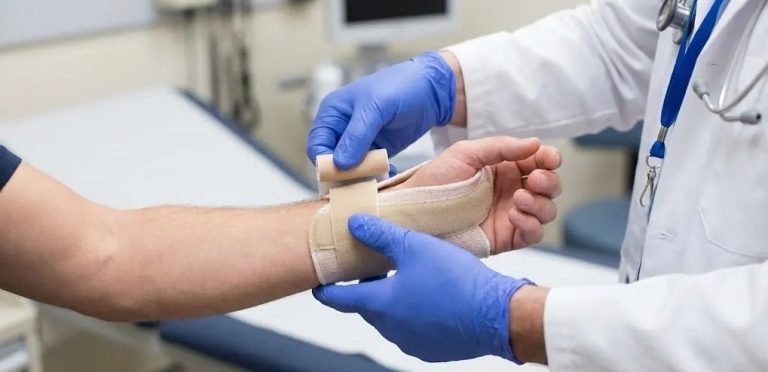 A close-up view of a no appointment doctor Houston applying a splint to a patient's wrist injury in an exam room.