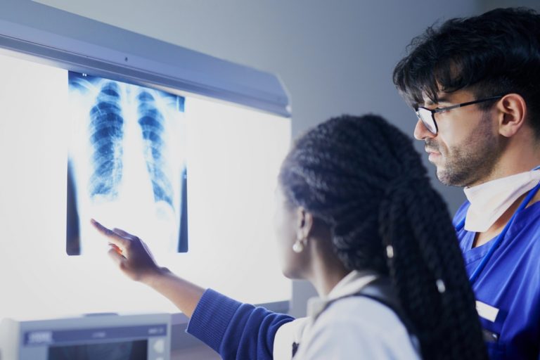 Doctors reviewing a chest X-ray, a typical diagnostic step at a walk-in clinic Ambetter insurance Houston facility