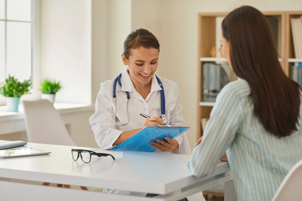 Doctor consulting female patient in clinic, discussing symptoms and care options for uti treatment houston services
