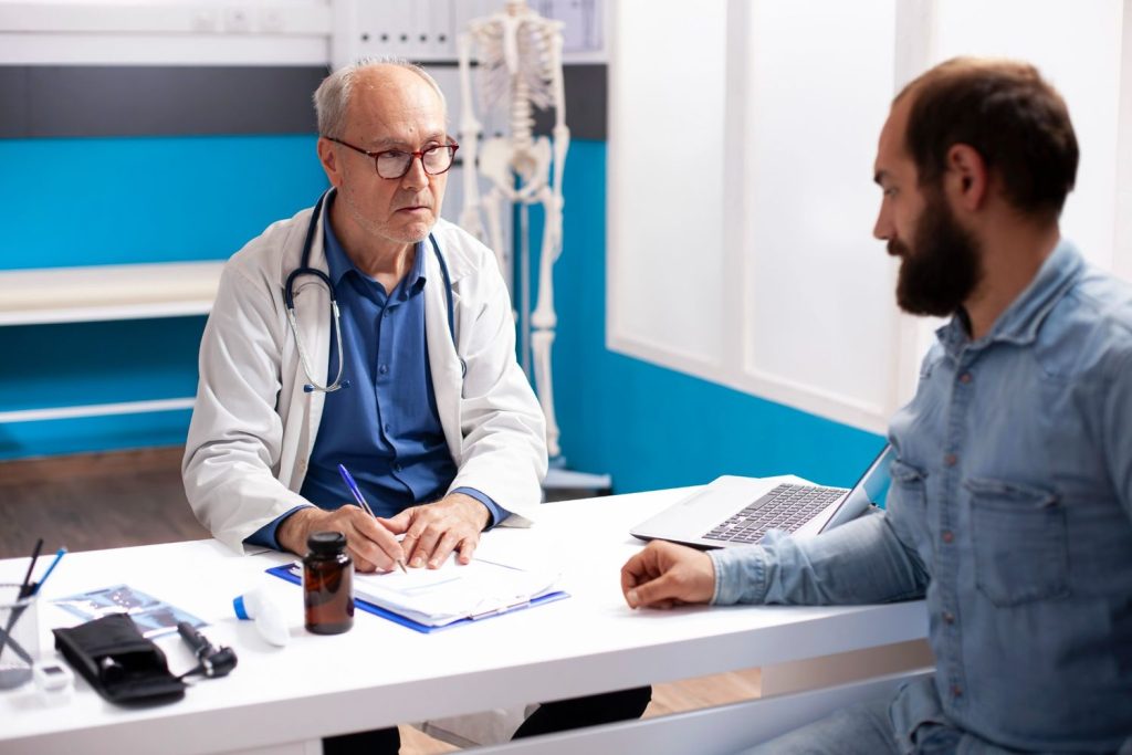 Doctor taking notes during a patient consultation at an Ambetter health urgent care clinic Houston facility.