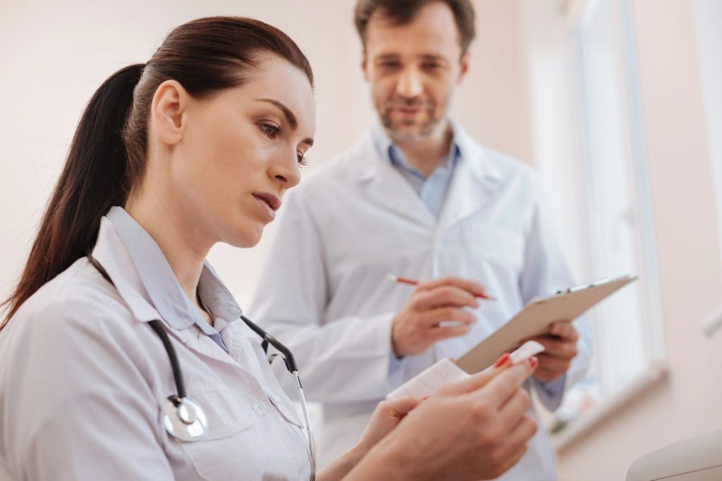 Female physician reviewing lab results at an Ambetter health urgent care clinic Houston with a colleague. 
