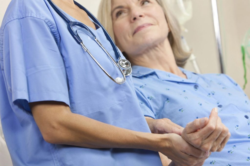 A compassionate female doctor Houston provides hands-on support and comfort to an elderly patient during a checkup.