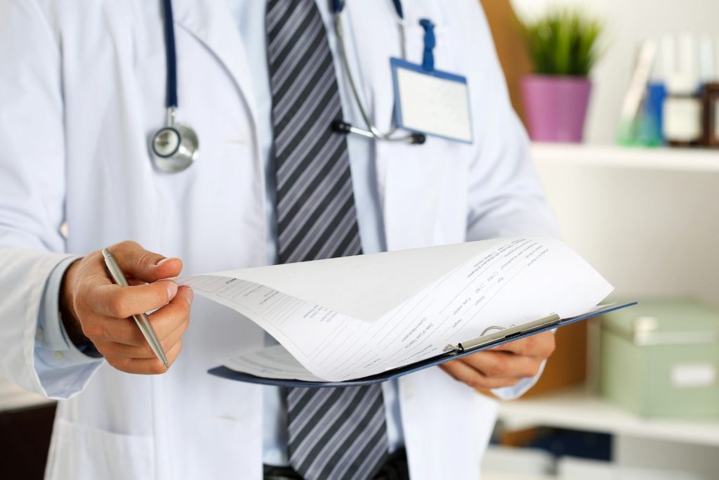 Professional medical staff at an immediate care clinic Houston review a patient's insurance and health history forms.