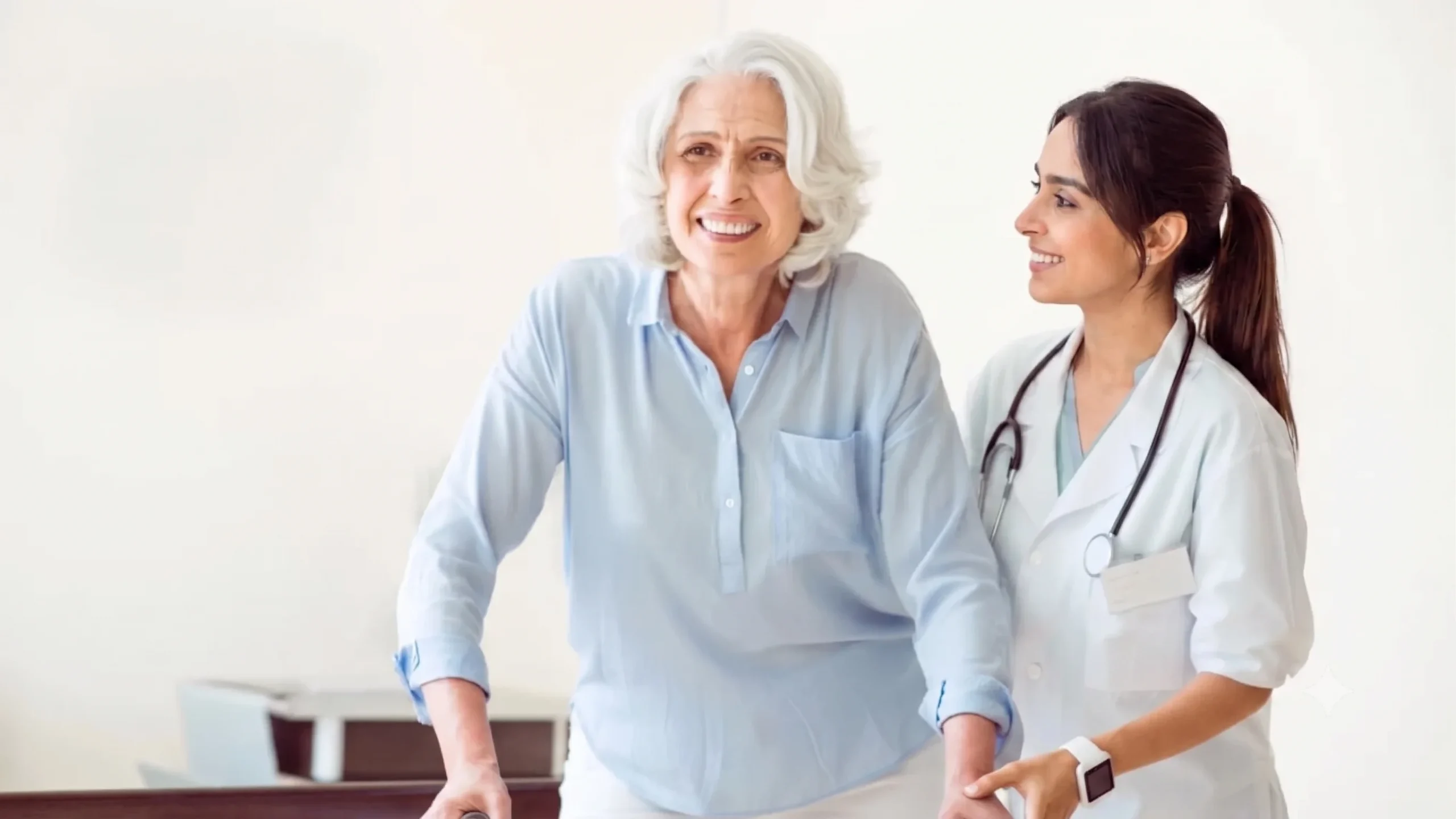 Female primary care doctor helping a smiling senior patient with a walker.