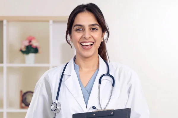 Laughing female primary care doctor holding a clipboard.